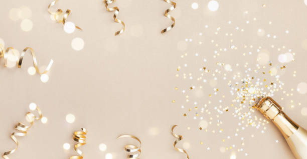 champagne bottle with confetti stars, bokeh decoration and party streamers on golden background. christmas, birthday or wedding concept. flat lay. - champagne champagne flute wedding glass imagens e fotografias de stock