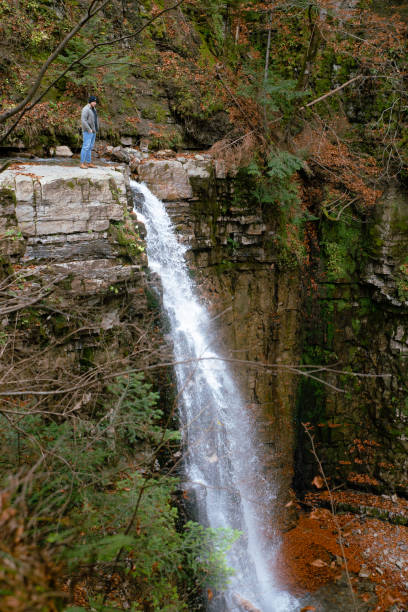 istock man at the edge looking on waterfall hiking concept 1176723548