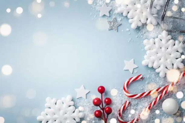 Christmas blue background. White snowflakes and holiday decoration top view. Happy New Year greeting card.