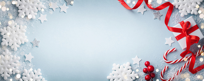 Fondo azul de Navidad. Caja de regalo o presente, copos de nieve blancos y vistas superiores de decoración navideña. Feliz tarjeta de Año Nuevo. Formato de banner. photo