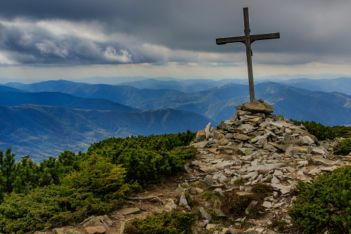Cross on top of Mount Strymba on a cloudy day near the village of Kolochava, Ukraine. Early autumn in the Carpathians.