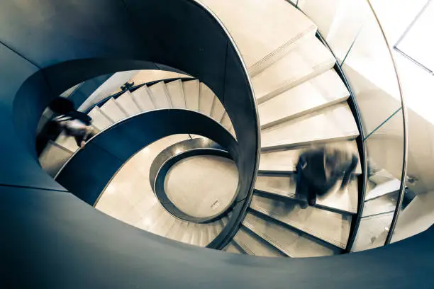 Photo of Blurred motion of Speeding Businessman on Abstract Spiral Staircase