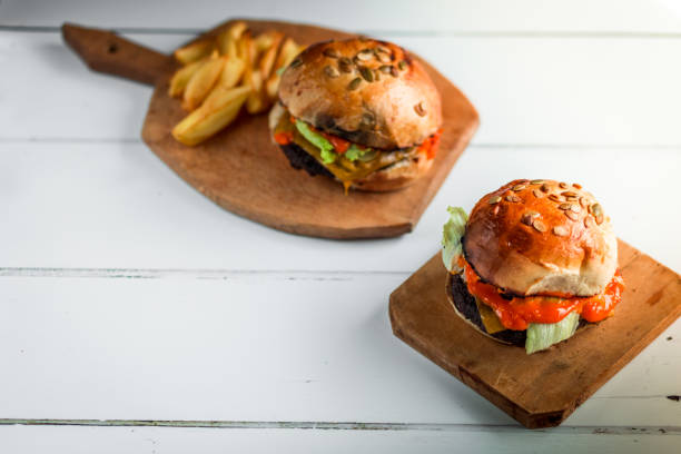 istock Fresh flame grilled burgers displayed on white wooden surface 1176734077