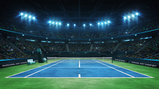 Blue tennis court and illuminated indoor arena with fans, upper front view