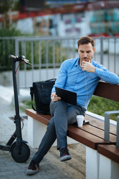 istock Businessman using digital tablet in the city park after scooter riding 1176735901