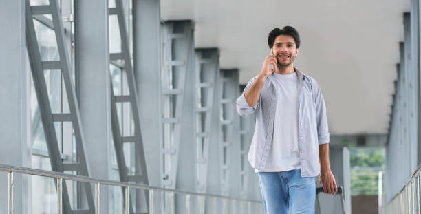 istock Young man talking on phone after arrival to airport 1176738116