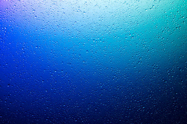 istock Water droplets on a translucent rainbow glass background with gradient 1176738417