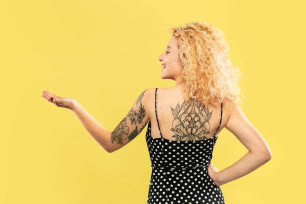 istock Caucasian young woman's half-length portrait on yellow background 1176738965