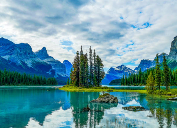 isla espíritu con monte paul y monkhead mountain, lago maligne, parque nacional jasper, canadá - lago maligne fotografías e imágenes de stock