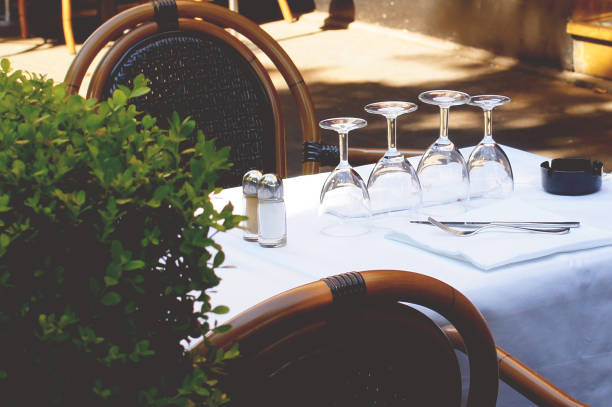 istock Empty glasses on the table with a white tablecloth in an outdoor restaurant. Wine glasses on a table in Paris. Aesthetics of Paris.Beautiful table and chairs in the restaurant 1176748117