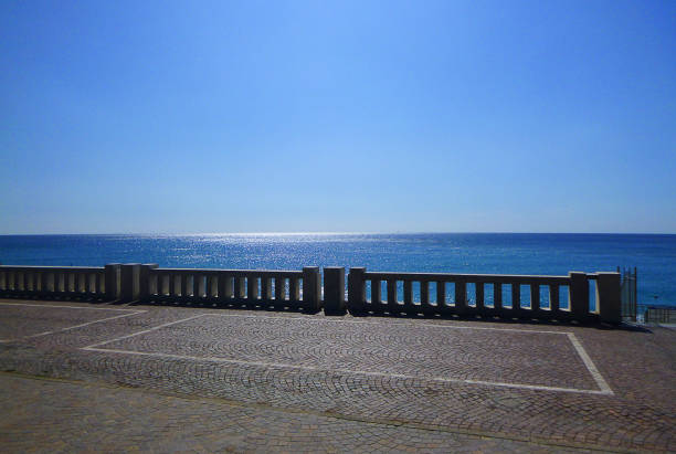 a railing on the coast in front of the sea