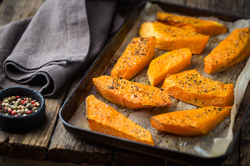 Baked pumpkin slices with honey, oil and herbs