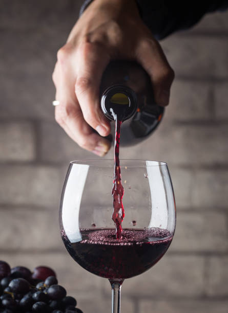 赤ワインを注ぐ - wine pouring wineglass red ストックフォ�トと画像