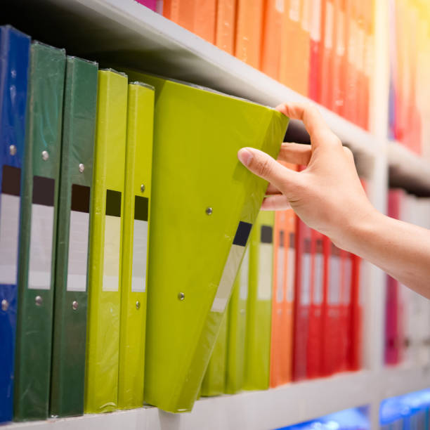 istock Male hand choosing file folder in stationery shop 1176750925