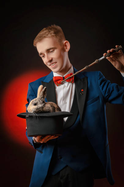 istock a young guy magician illusionist holding a hat with a rabbit 1176753944