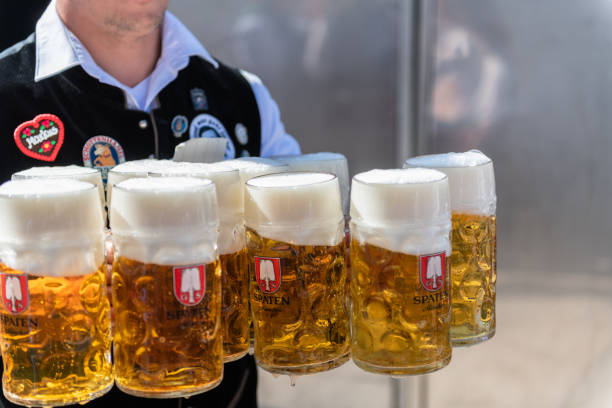 waiter carrying a lot of beers outdoors at octoberfest - serving drink beer garden beer glass imagens e fotografias de stock