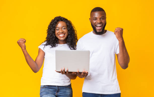 istock Excited african couple celebrating win with laptop 1176757250