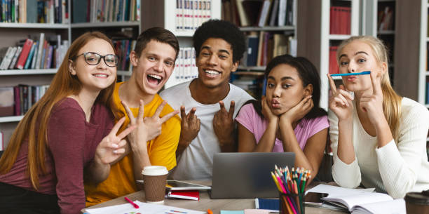 istock Funny group of students posing at camera in library 1176757565
