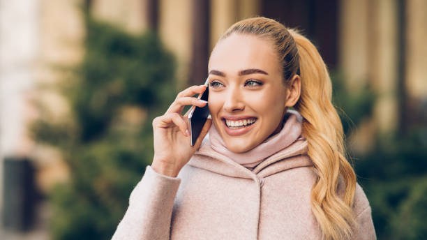 istock Millennial woman talking on phone outdoors, waiting for friend 1176757796