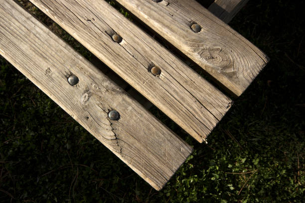 Old weathered wooden planks. Bench and grass.