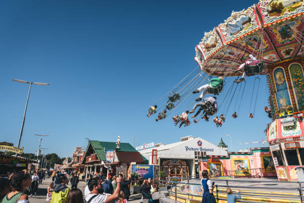 Munich , Germany - September 21, 2019: low angle view on people in motion on carousel at Oktoberfest in Munich under blue sky