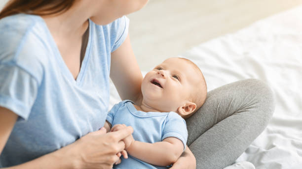 istock Adorable little baby smiling while lying on mother's laps 1176760124