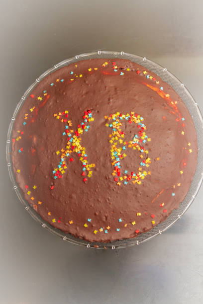 istock Chocolate cake at Easter with inscription of HV with colored sprinkles. 1176761305