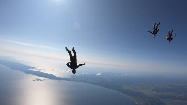 istock Skydivers fall through clear skies, in aerial flight 1176763645