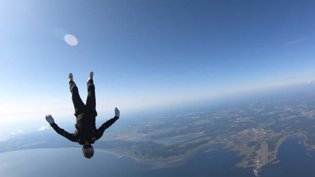 istock Skydiver falls through clear skies, in aerial flight 1176763822