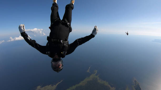 istock Skydivers fall through clear skies, in aerial flight 1176764763