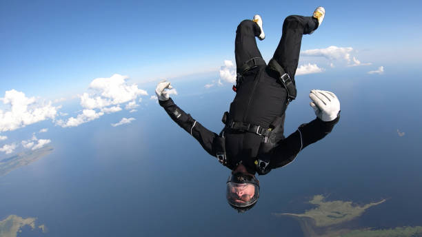 istock Skydiver falls through clear skies, in aerial flight 1176765692