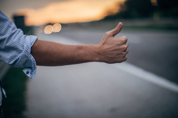 istock Hitchhiker with thumb up by the road 1176767154