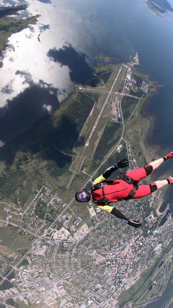istock Skydiver falls through clear skies, in aerial flight 1176770462