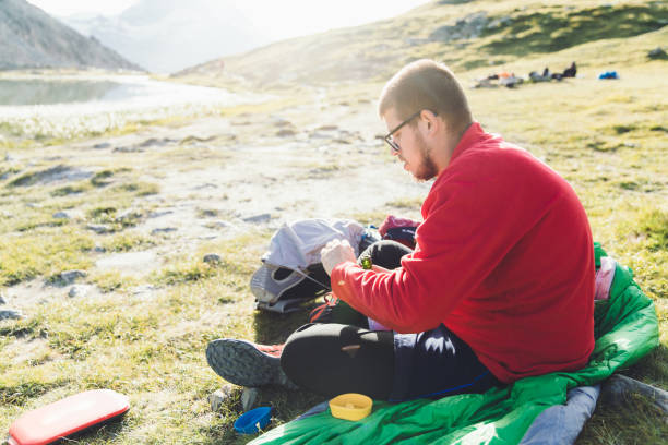 istock Man backpacker having summer picnic in Swiss Alps 1176770791