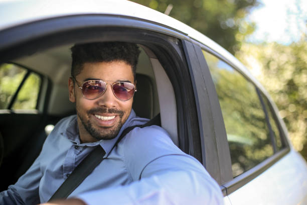 afrikanischer mann fährt ein auto - aviator glasses stock-fotos und bilder