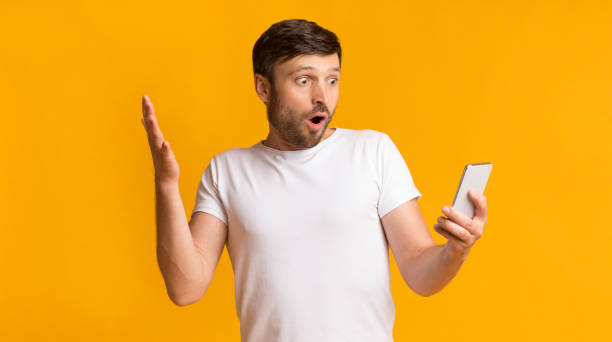 istock Shocked Guy Looking At Cellphone On Yellow Background, Panorama 1176771012