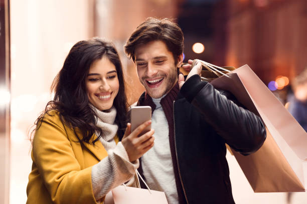 istock Order clothes online. Couple after shopping in mall using phone 1176771191