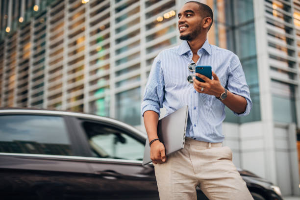 Black businessman using phone on the street