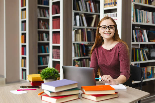 istock Young female scientist smiling at camera, studying at library 1176771930