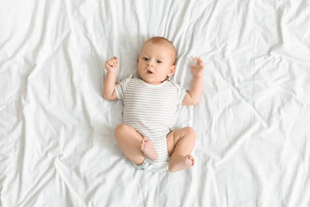 istock Curious baby lying on bed and looking to camera 1176772023