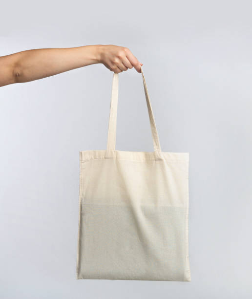 istock Hand Holding White Blank Eco Bag Over Studio Background 1176772413