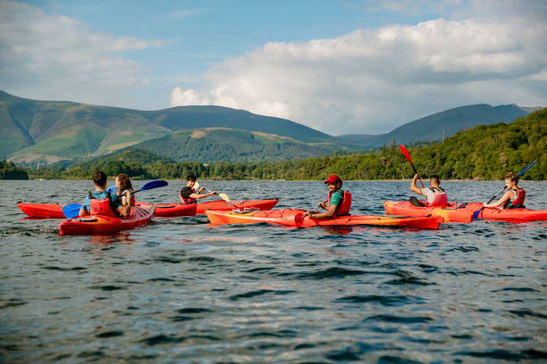 Friends Bonding on Kayaks A group of friends bonding in Kayaks on Derwent Water in The Lakes District in Cumbria derwent water stock pictures, royalty-free photos & images