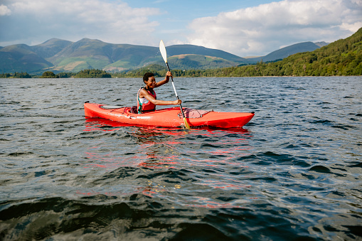 A single mixed race female kayaking on Derwent Water in The Lake District in Cumbria