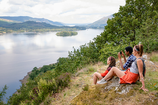 A group of young females taking a rest and enjoying the stunning scenery of Derwent Water in The Lake District in Cumbria