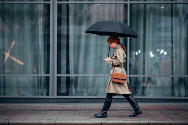 kobieta idąca z parasolem - people in a row in a row business office worker zdjęcia i obrazy z banku zdjęć