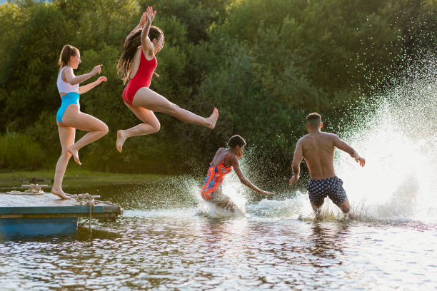istock Young Friends Running and Jumping off a Jetty into a Lake 1176776184