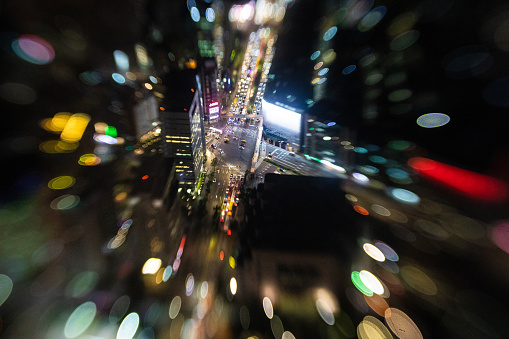 Lensbaby photography at night from high rooftop, directly above view  of city street and traffic