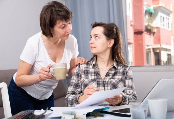 istock Two smiling women sitting at home table with laptop 1176776371