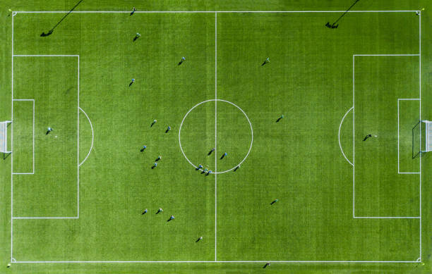 Green football pitch Aerial View Aerial view of Green football pitch with unrecognizable little player silhouettes; outdoors. soccer field photos stock pictures, royalty-free photos & images