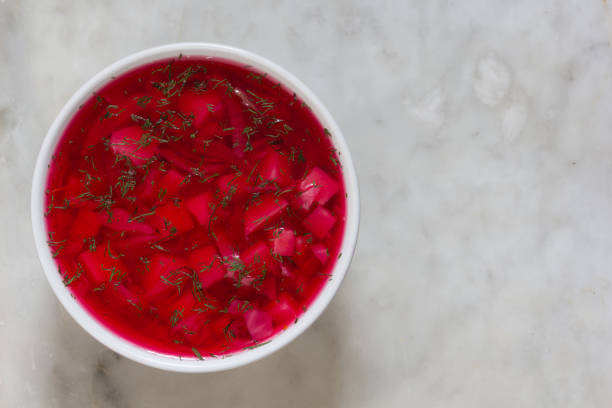 istock Top view of beetroot soup in white bowl on white marble background 1176778996
